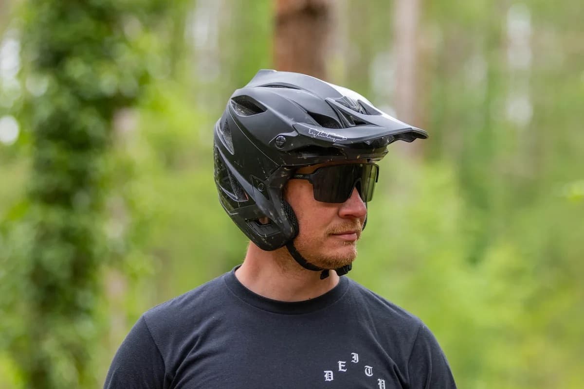 Athlete in a trail helmet and shades, mountains behind